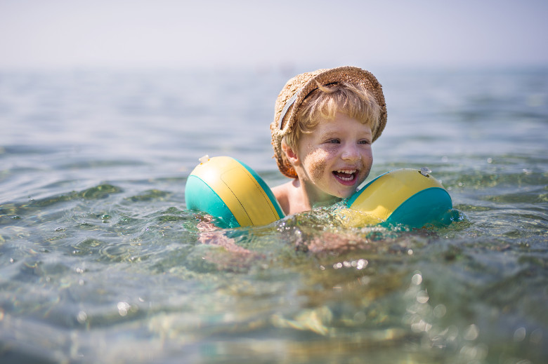 nasmejan decak u moru sa misicima za plivanje i kapom