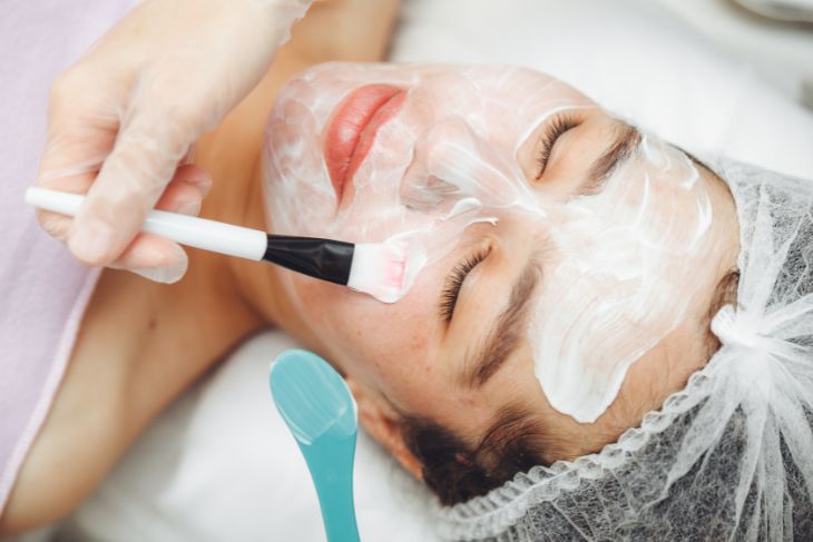 Devojci stavljaju hranljivu masku za lice u salonu lepote.