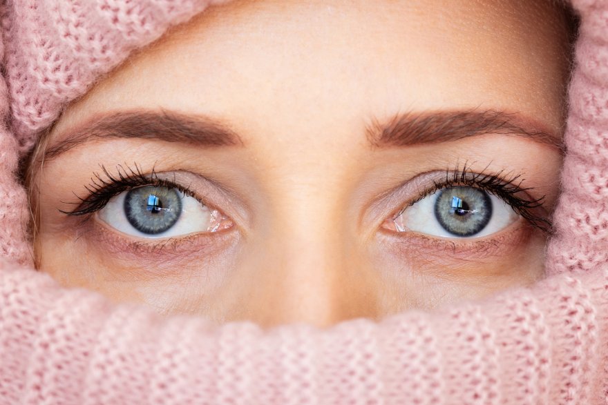 Devojka sa plavim očima umotana u roze šal